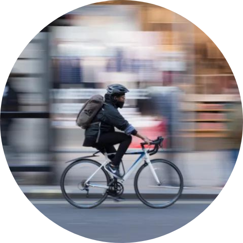 black man riding bike fast through city