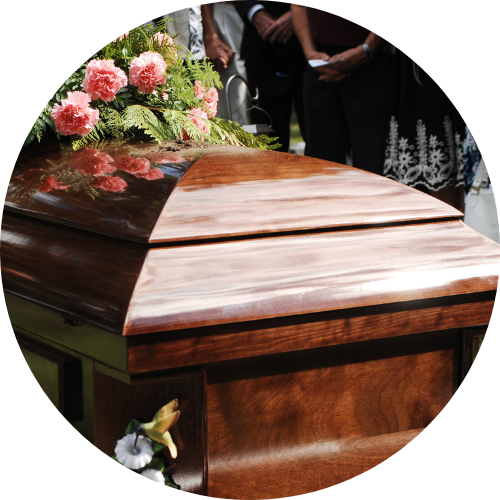 dark wood coffin with family standing around at funeral