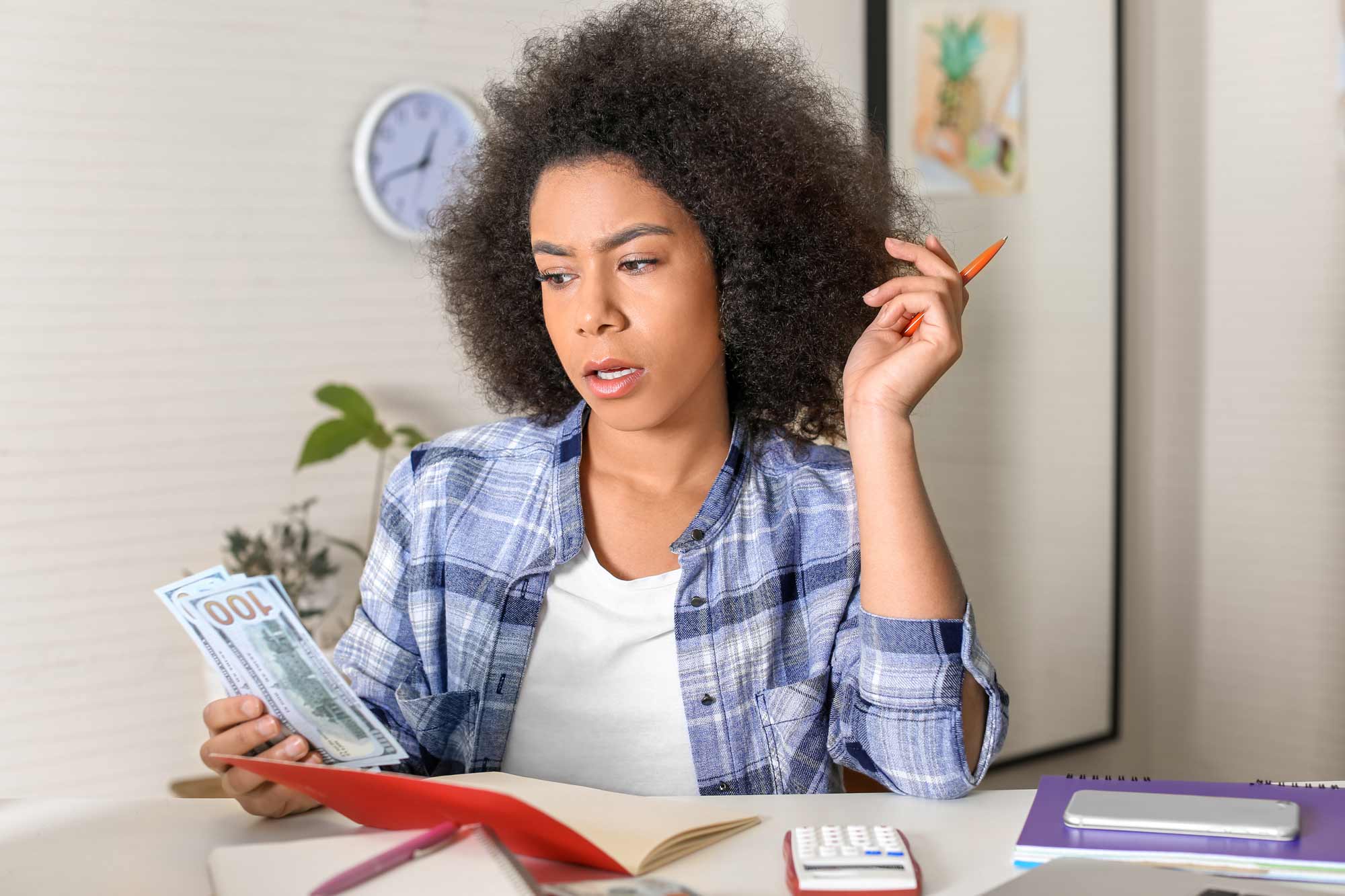 woman looking concerned at money she is holding