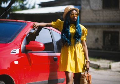 black woman dressed for summer standing next to her car