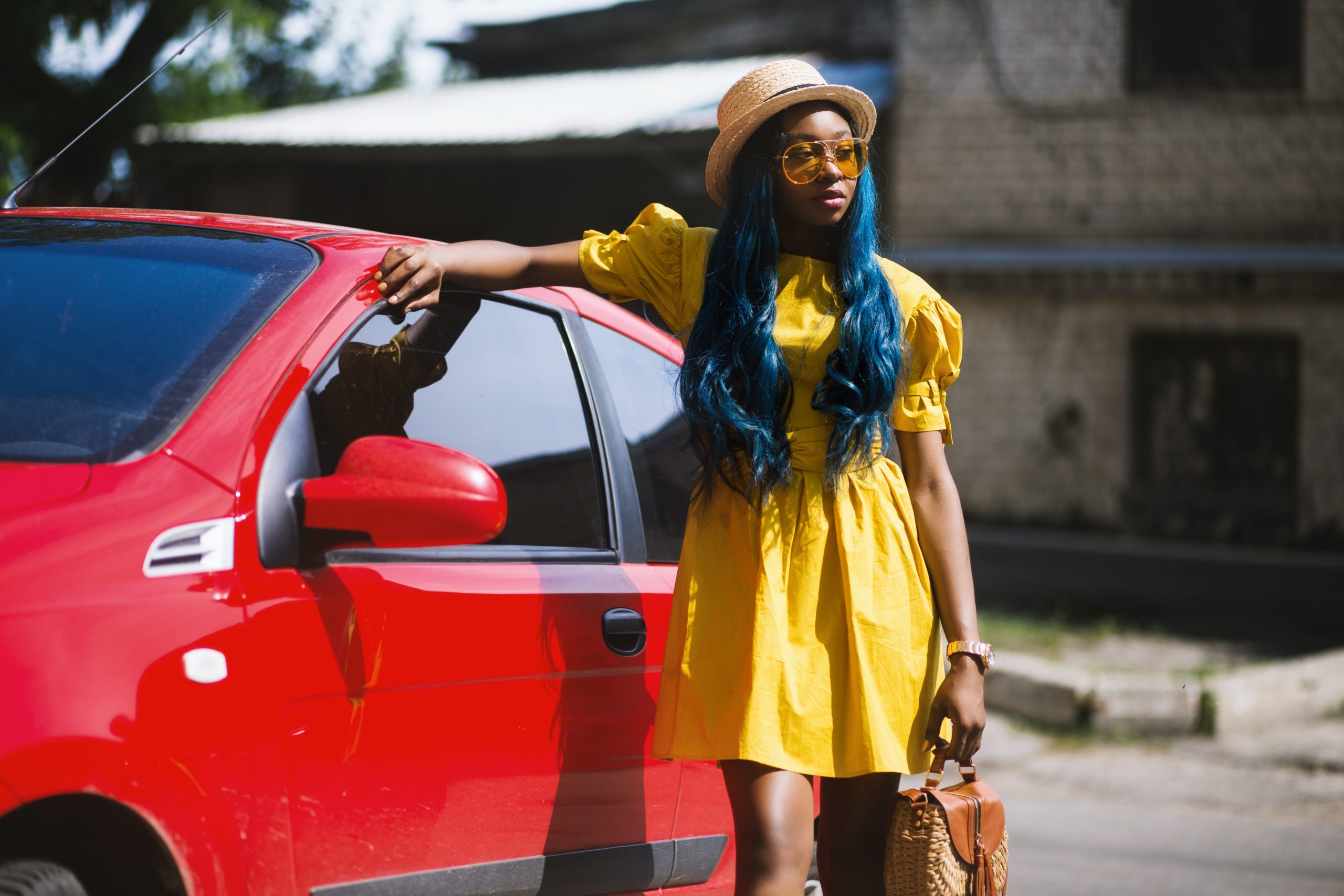 black woman dressed for summer standing next to her car