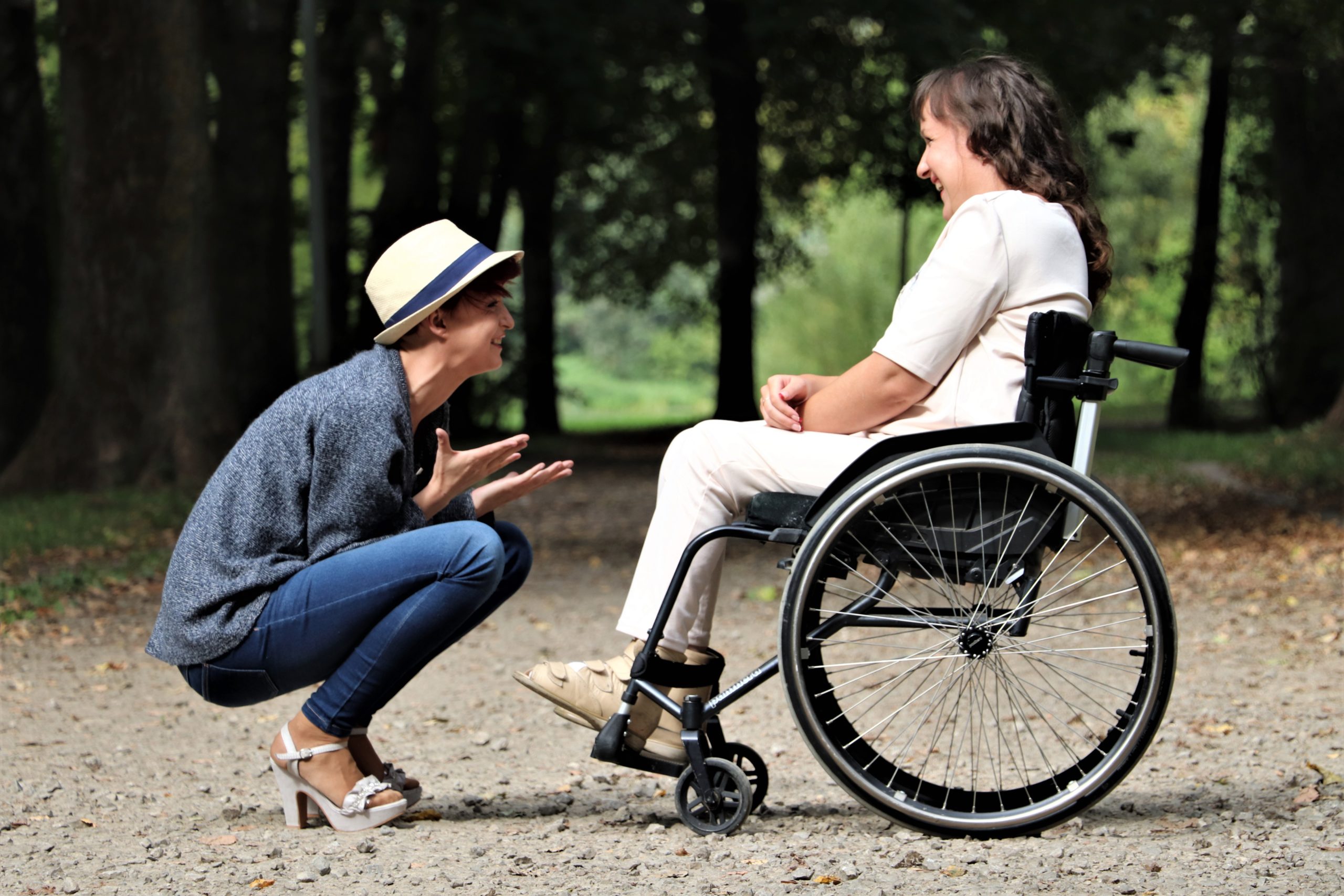 person smiling excited to see their friend who is in a wheelchair