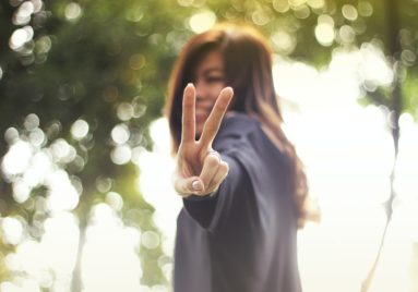 asian woman making a peace sign