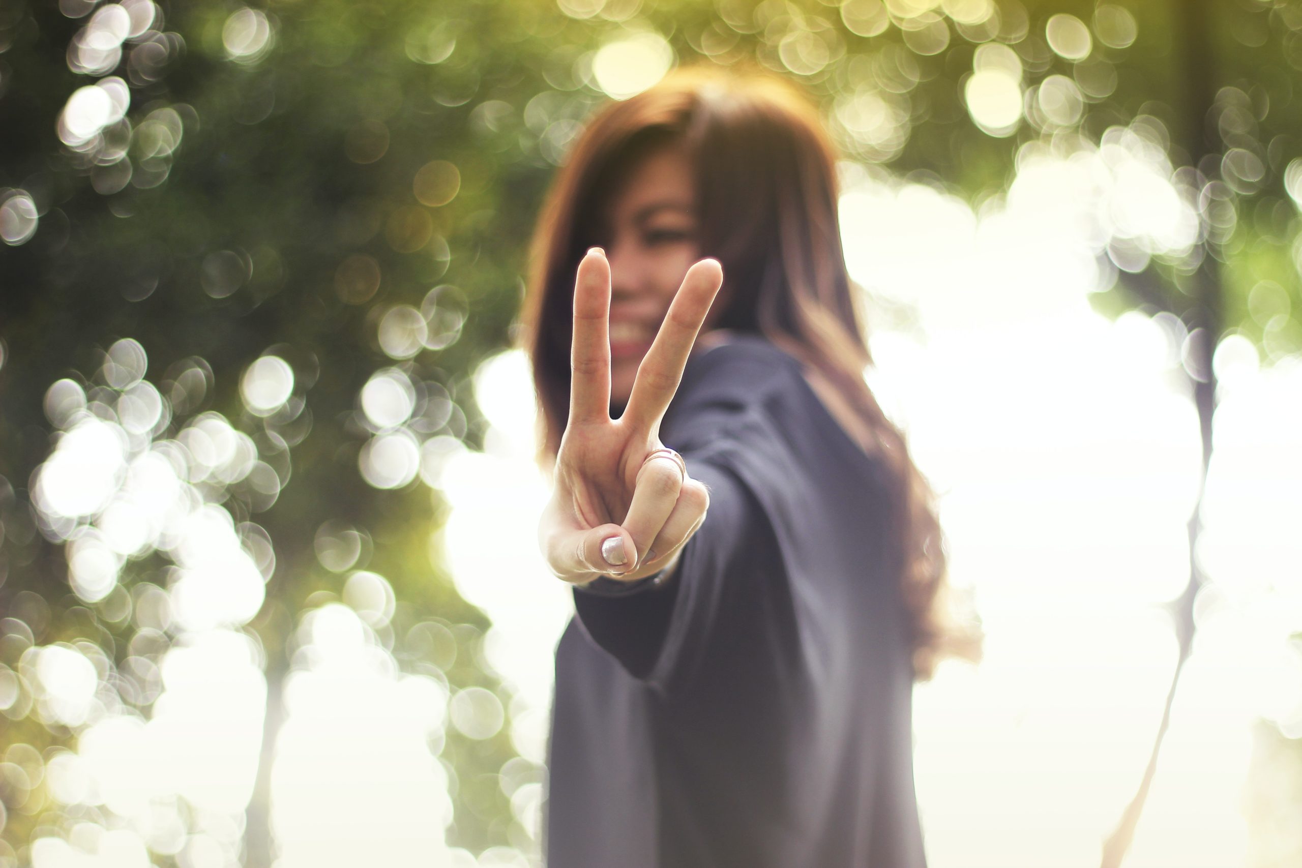 asian woman making a peace sign