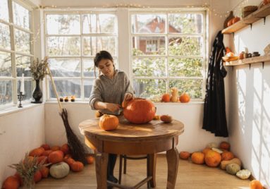 woman carving pumpkin for halloween