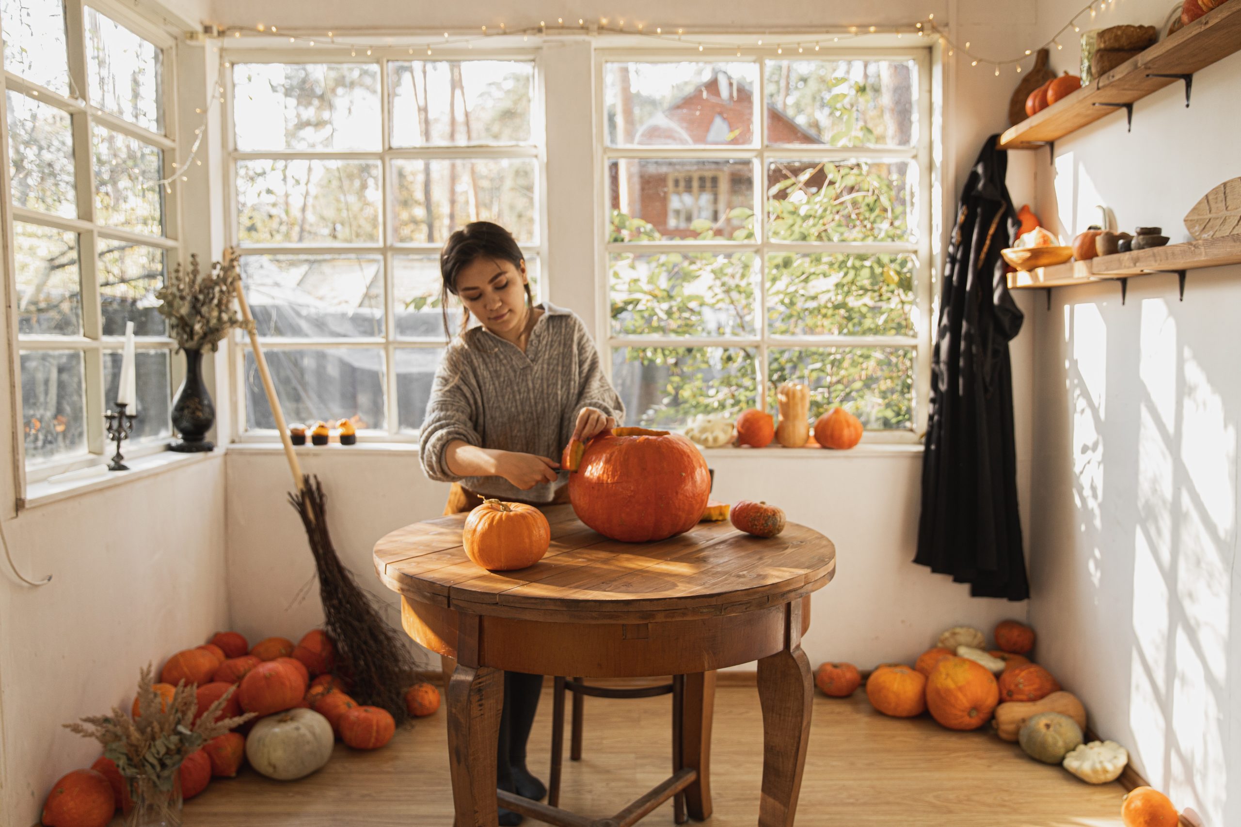 woman carving pumpkin for halloween