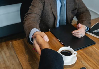 people shaking hands at business meeting