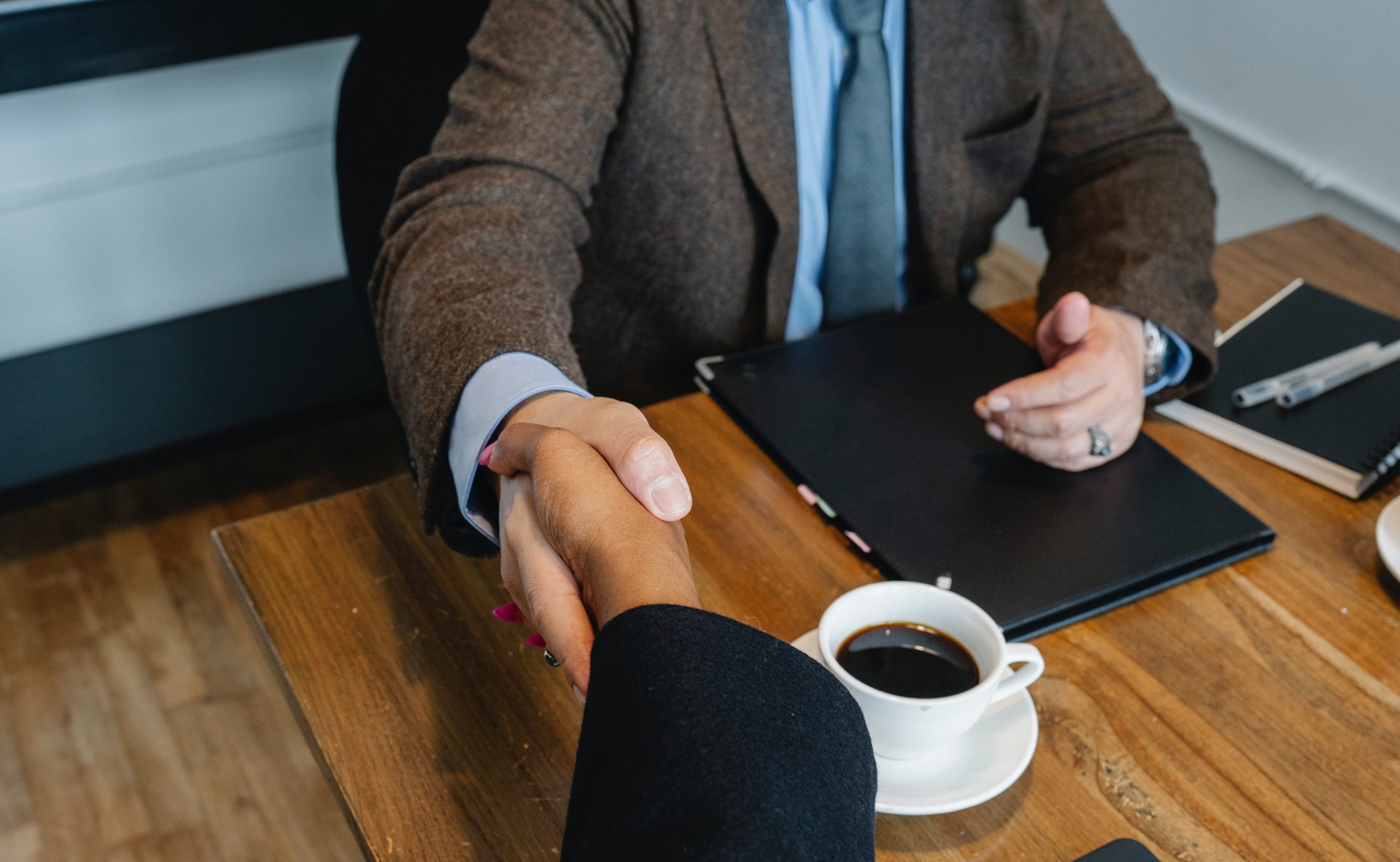 people shaking hands at business meeting